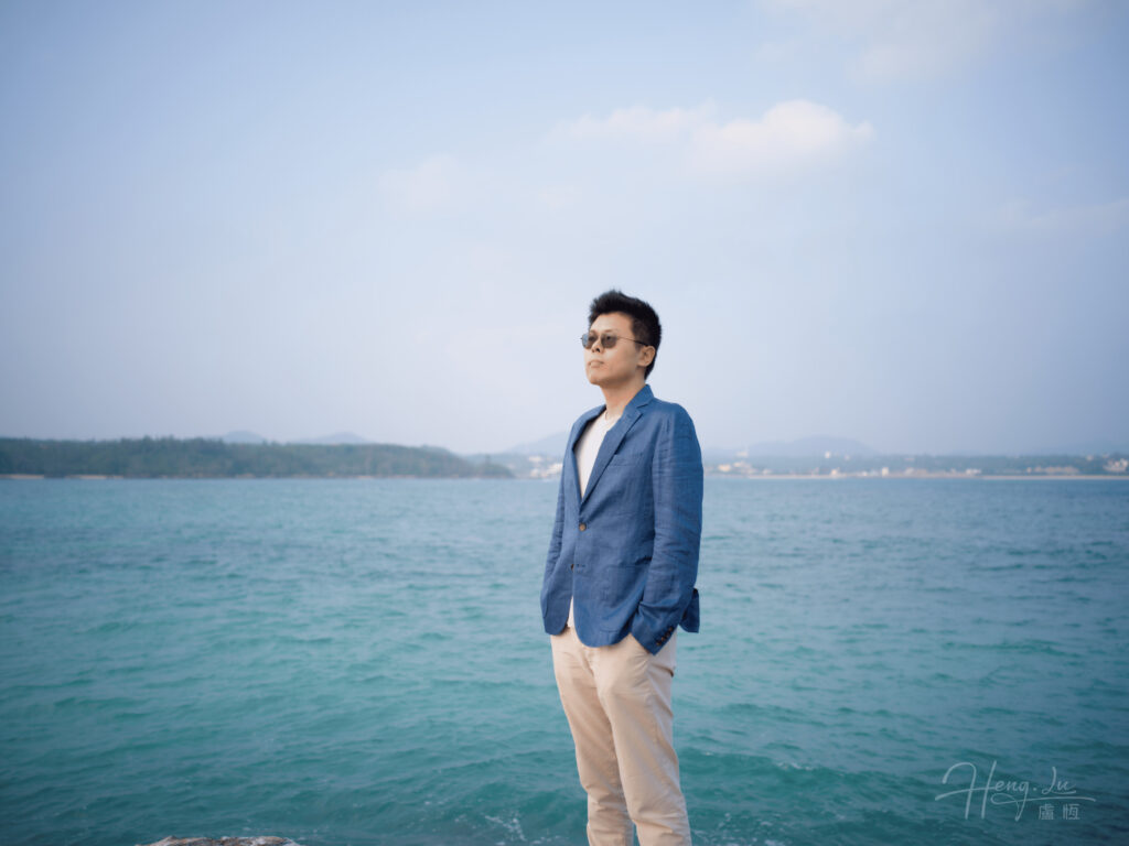 Luheng standing by the sea in a blue blazer