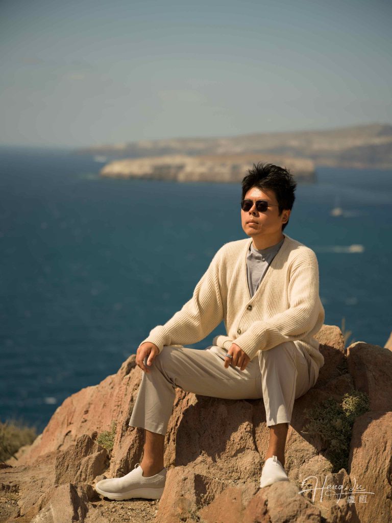 Luheng-in-sunglasses-sitting-on-coastal-rock
