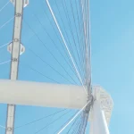 Upward view of Ferris wheel cables against bright sky A-close-up-of-a-Ferris-wheel-against-sky