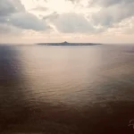 Serene View of a Distant Island Over Calm Sea Waters Distant-island-viewed-over-calm-sea (1)