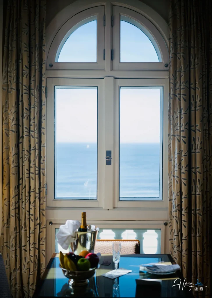 Elegant-window-view-overlooking-ocean-with-fruits-and-champagne
