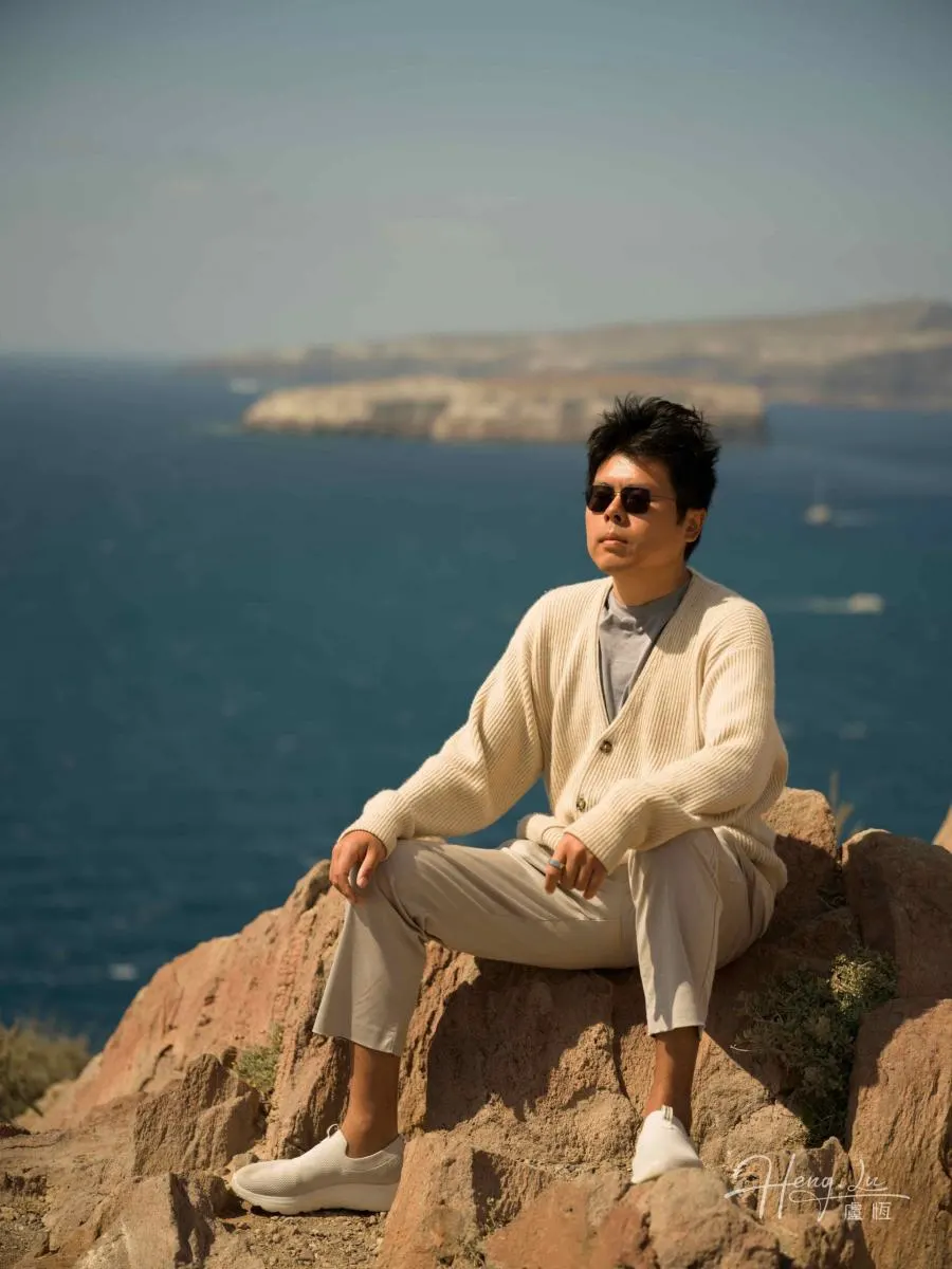 Luheng-in-sunglasses-sitting-on-coastal-rock