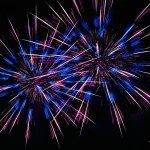 Blue-and-pink-fireworks-burst-vividly-in-night-sky