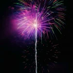 Colorful-firework-explodes-with-radiant-purple-glow-against-night-sky