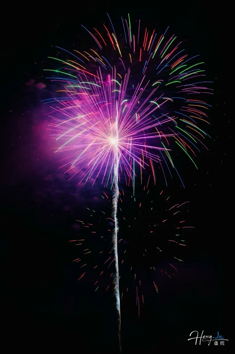 Colorful-firework-explodes-with-radiant-purple-glow-against-night-sky