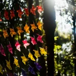 Colorful-paper-windmills-hanging-in-forest-sunlight