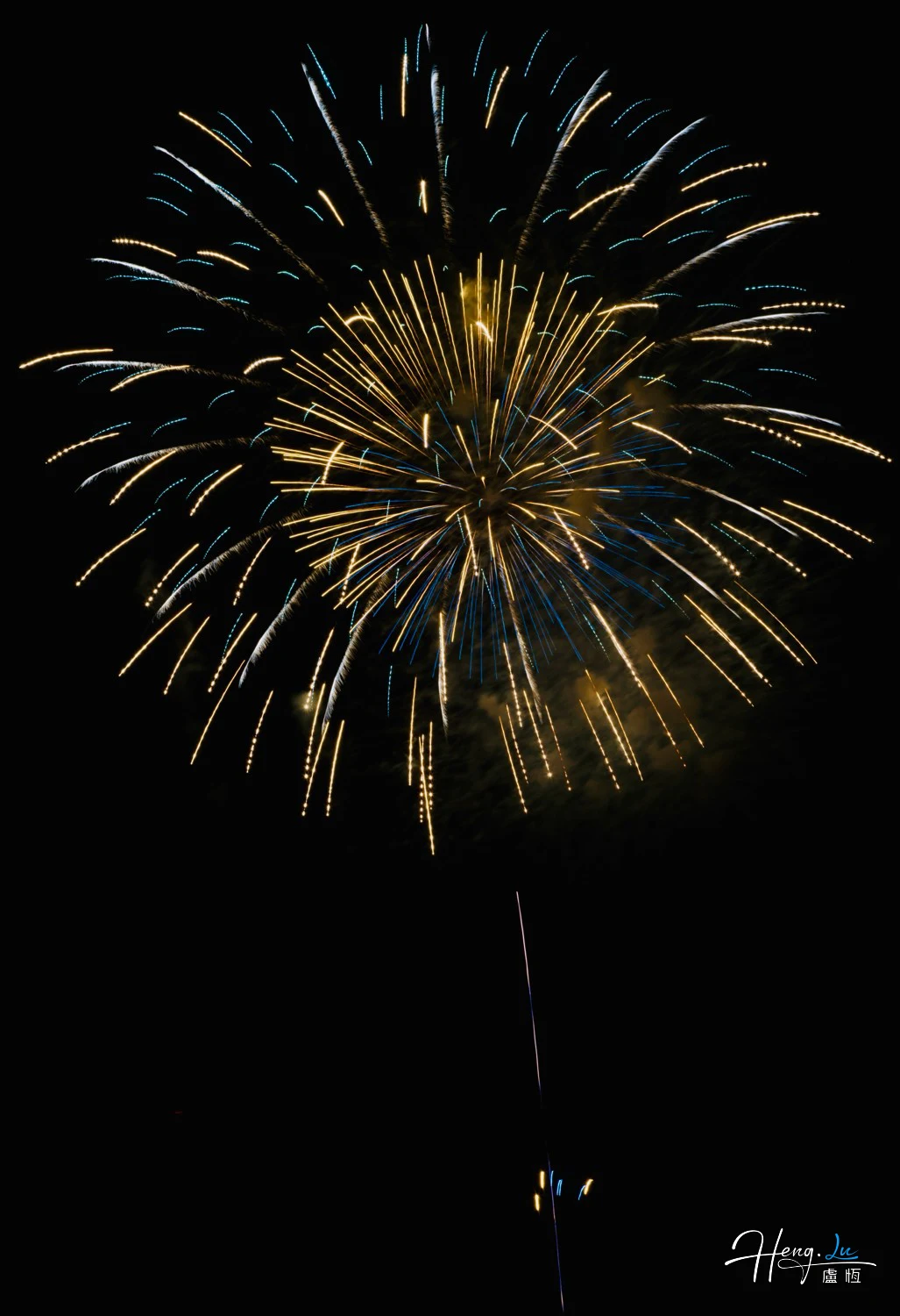 Golden-and-blue-firework-bursts-gloriously-against-dark-midnight-sky