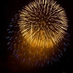 Golden-and-blue-fireworks-burst-brightly-in-night-sky