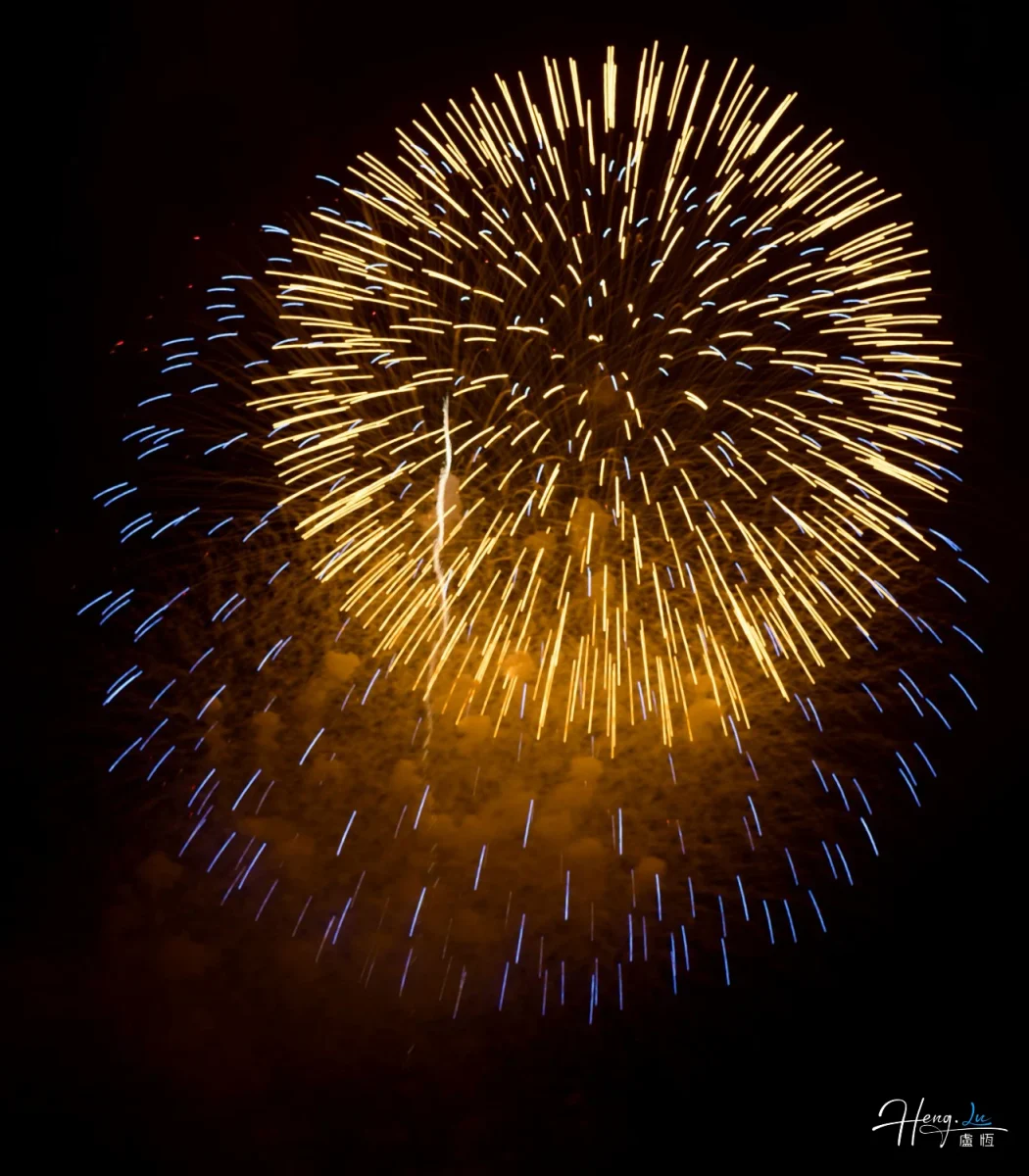 Golden-and-blue-fireworks-burst-brightly-in-night-sky