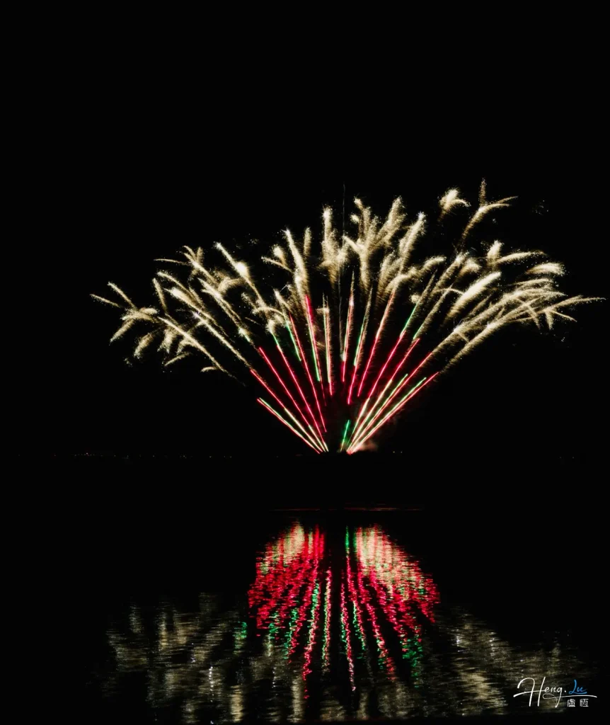 Golden-and-red-fireworks-reflect-brightly-over-calm-water