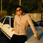 Luheng-leaning-on-white-car-under-sunset-light