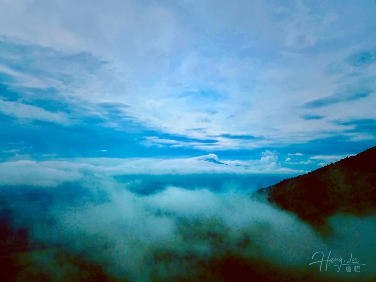 Mountain-peak-above-clouds-under-blue-sky
