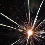 Radiant-firework-explodes-outward-like-bursting-star-in-darkness