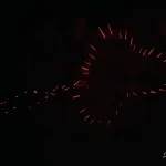 Red-firework-trails-forming-heart-shape-in-dark-sky