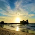 Rusty-shipwreck-on-beach-during-sunset-in-Africa