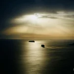 Ship-sailing-under-dramatic-sunset-sky