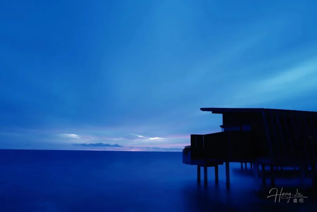 Silhouette-of-sea-villa-on-stilts-over-ocean