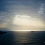 Sunlight-rays-over-calm-ocean-horizon