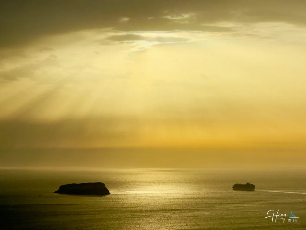 Sunrays-over-sea-with-island-and-ship