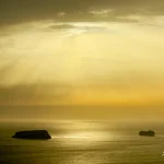 Sunrays-over-sea-with-island-and-ship