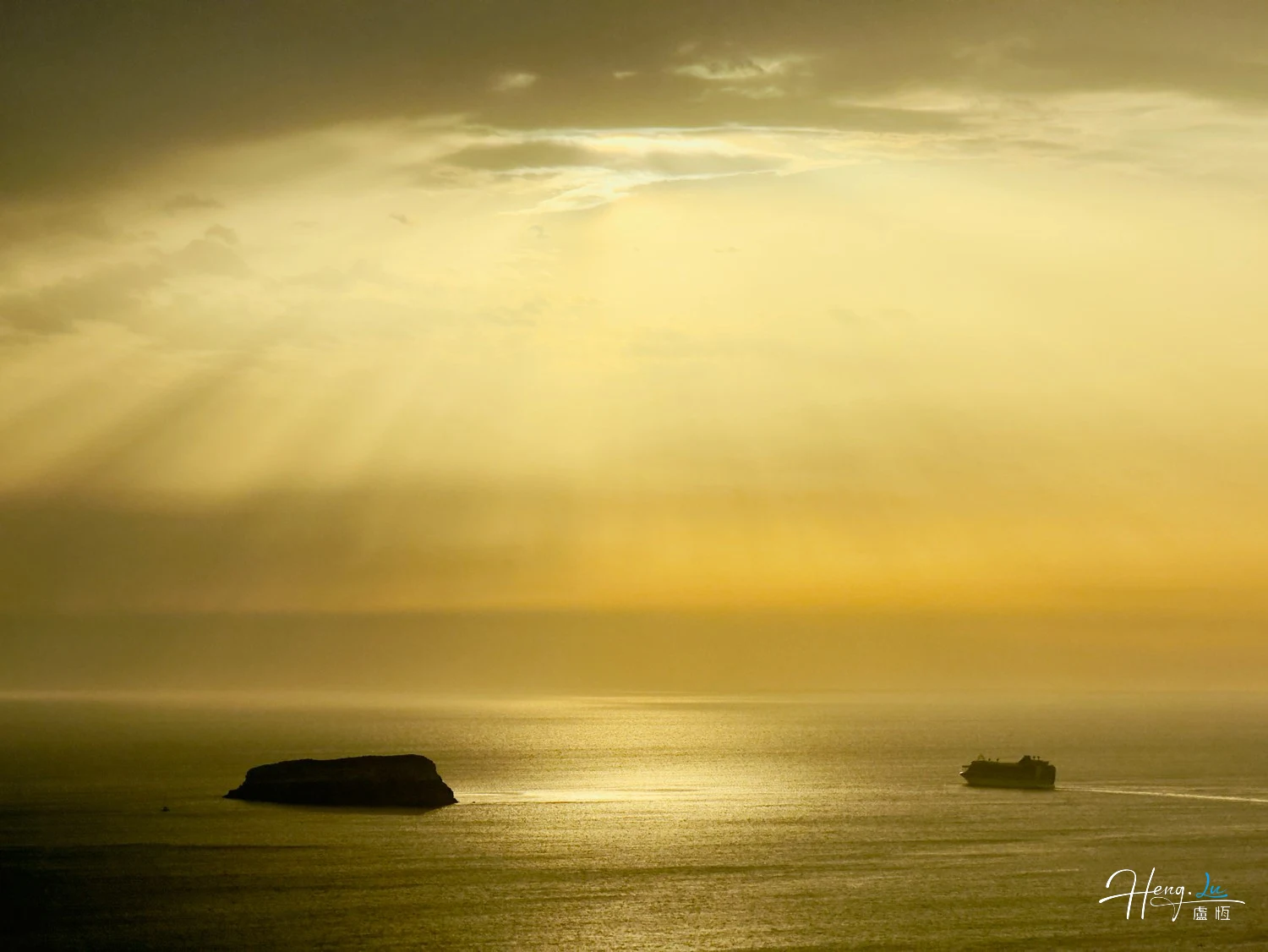 Sunrays-over-sea-with-island-and-ship