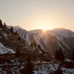 Sunrise-over-snowy-mountain-slopes-with-pine-trees