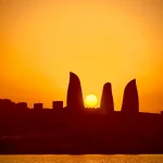 Sunset Over a Modern City: A Silhouette by the Water Sunset-over-modern-city-silhouette-by-water