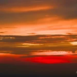 Vibrant-orange-and-red-sunset-over-cloudy-evening-sky