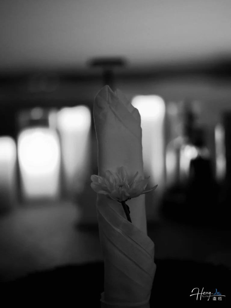 black-and-white-folded-napkin-holding-single-flower