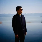 luheng-standing-by-lake-under-clear-blue-sky