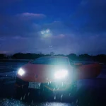 sports-car-with-headlights-on-in-rainy-night