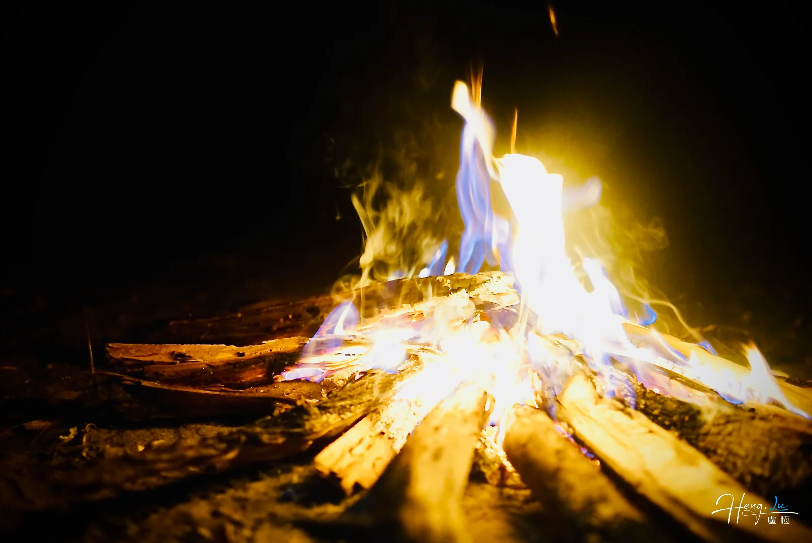 campfire-with-blue-and-yellow-flames-in-darkness