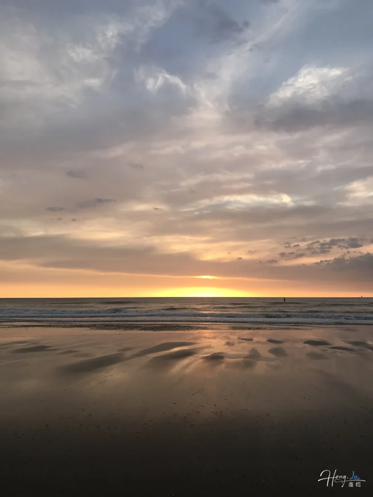 pastel-sunset-reflecting-on-calm-beach-shore