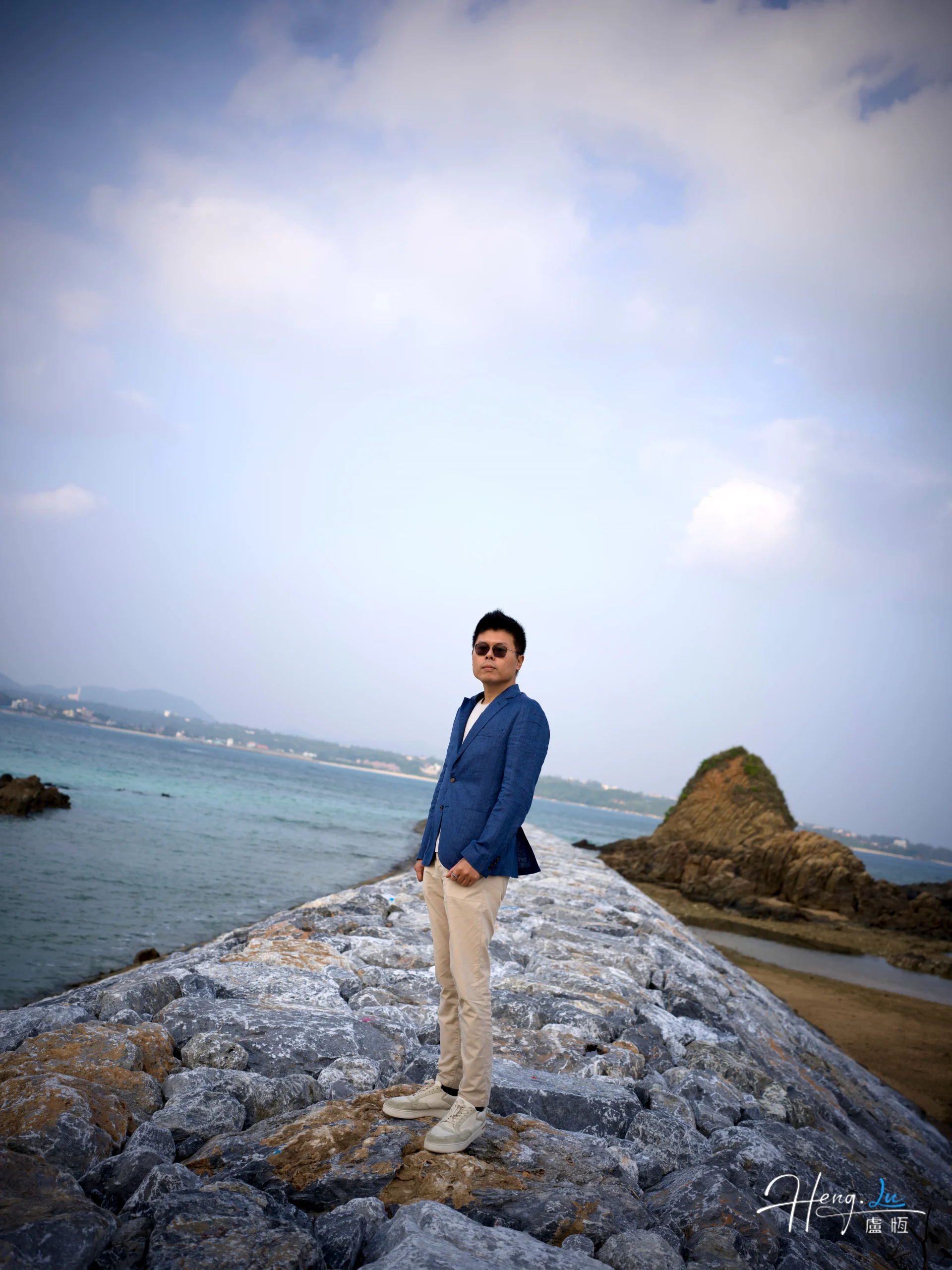 luheng-standing-on-rock-path-by-the-sea-scaled