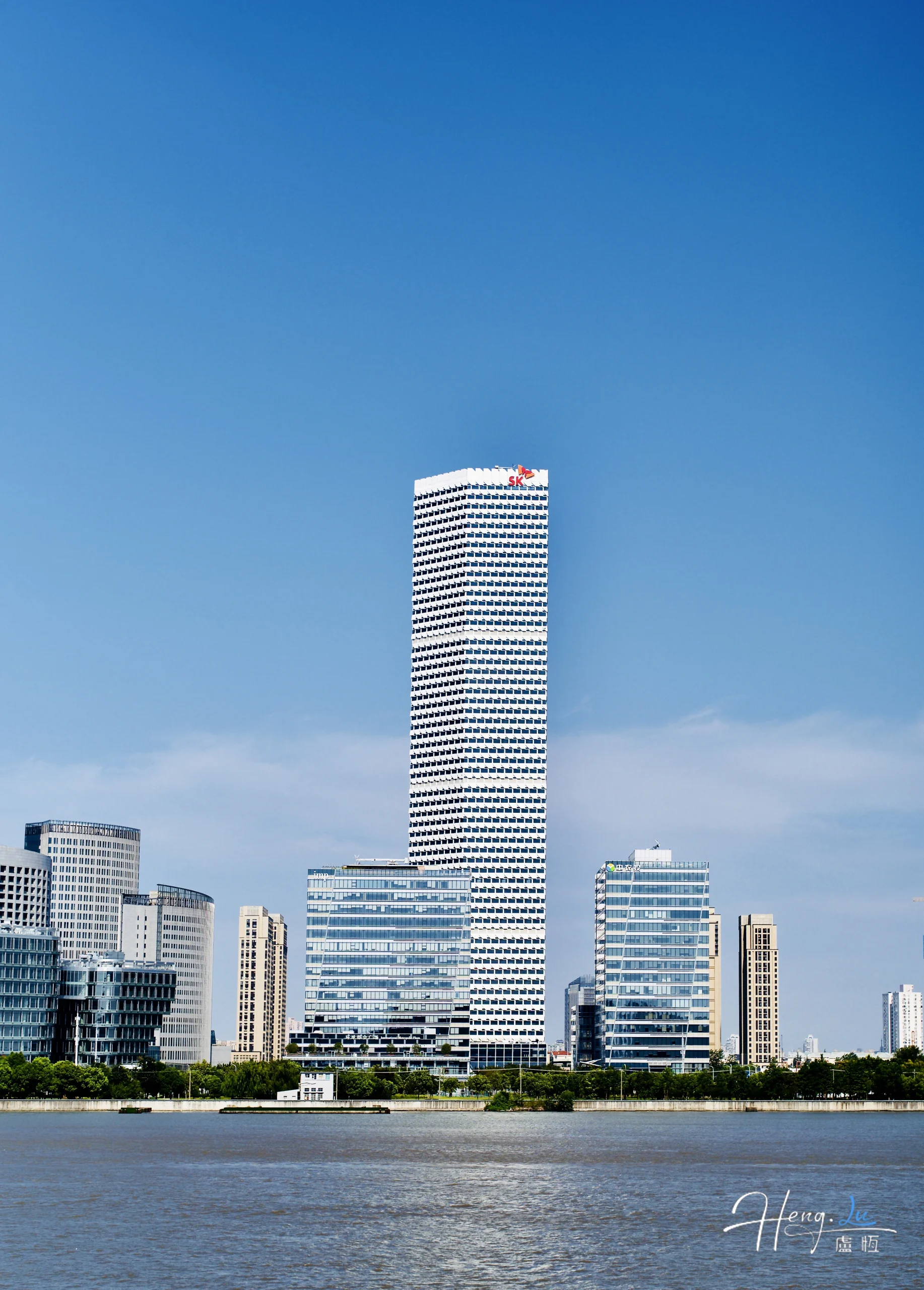 Modern skyscraper with blue sky and riverfront view modern-skyscraper-with-blue-sky-and-riverfront-view