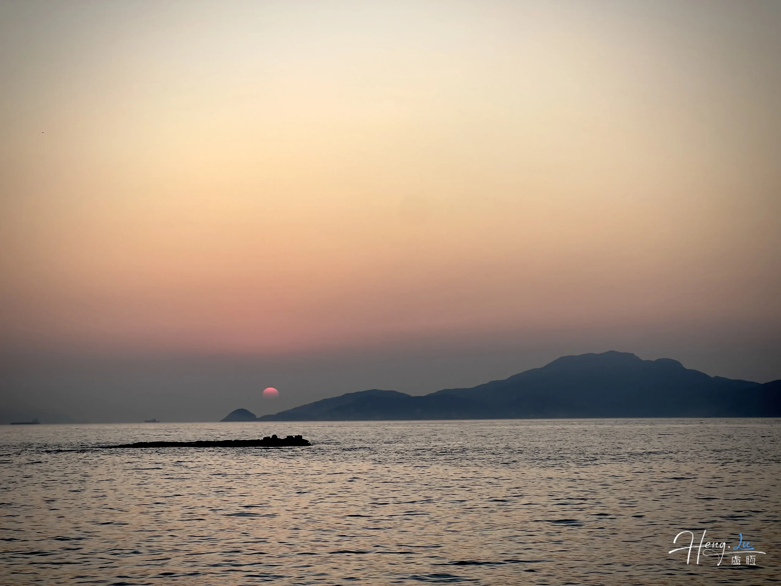 sunset-over-sea-with-distant-mountains