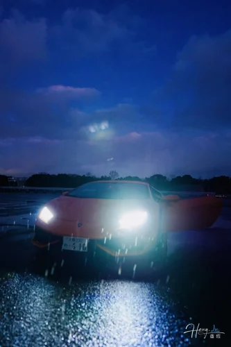 sports-car-with-headlights-on-in-rainy-night