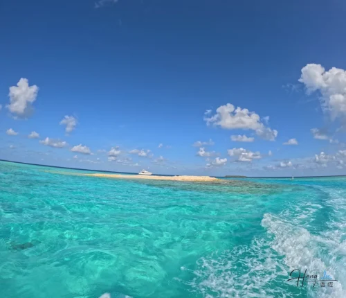 turquoise-sea-with-small-island-and-boat-under-blue-sky