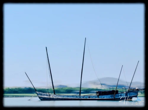 wooden-sailboat-on-calm-lake-under-blue-sky